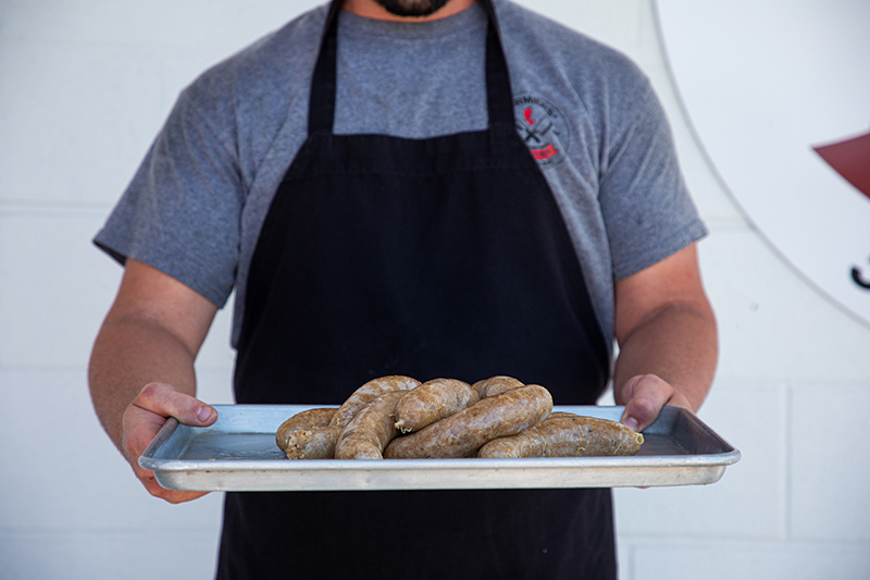 man holding tray of boudin